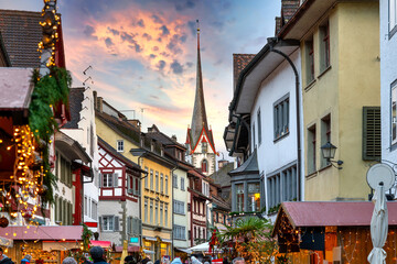 Obraz premium Christmas Atmosphere in the Historic Old Town of Stein am Rhein with Market Stalls, Festive Lights and Church Tower