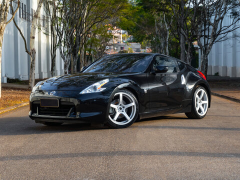 Black Nissan 370Z parked on a tree-lined road - Modern Japanese sports car