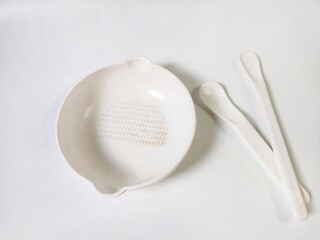 White Set of children's bowl and spoons on the white background. Baby tableware. Nutrition and first level Baby's feeding concept