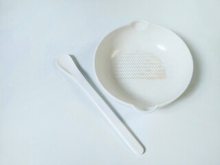 White Set of children's bowl and spoon on the white background. Baby tableware. Nutrition and first level Baby's feeding concept