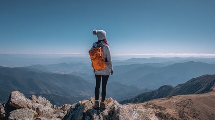 The woman enjoys a breathtaking view from the mountain peak.