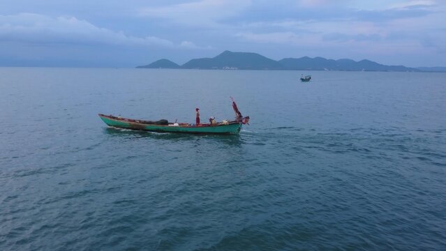 Witness stunning aerial views of Koh Tonsay as fishermen navigate calm waters at sunrise. This serene island is perfect for relaxation and adventure seekers alike.