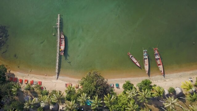 Koh Tonsay, a serene island in Cambodia, showcases tranquil waters and vibrant boats at sunrise, inviting relaxation in a tropical paradise.