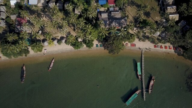 Experience the stunning aerial view of Koh Tonsay in Cambodia at sunrise, featuring palm trees, sandy beaches, and serene waters, perfect for relaxation and exploration.