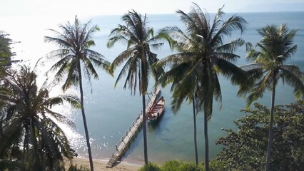 Fototapeta premium Witness the stunning aerial beauty of Koh Tonsay, Cambodia, as the sun rises over the tranquil waters, surrounded by palm trees and picturesque beaches.