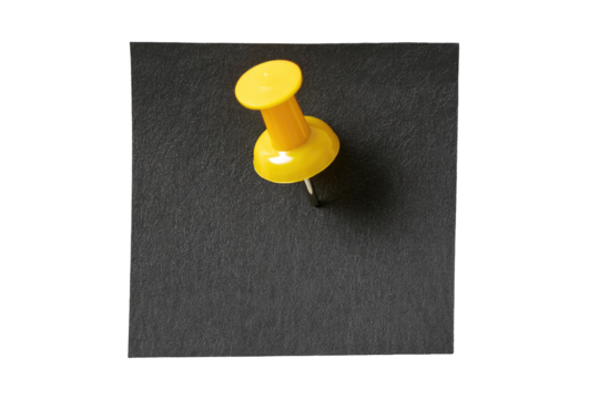 A bright yellow pushpin, head-first, affixed to a dark gray surface