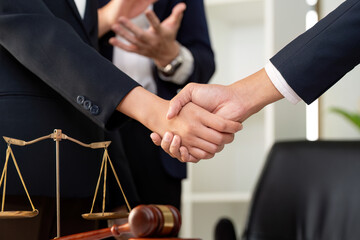 Legal Collaboration. Professionals discussing case strategy with handshake in law office.