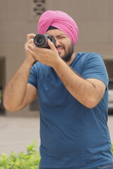 Fototapeta premium Vertical Photo of Sikh Indian Man Clicking Picture with Camera