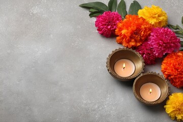 Vivid marigolds green leaves  lit tea lights adorn a textured gray surface