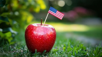 Red apple with small flag on grass, outdoors - Powered by Adobe
