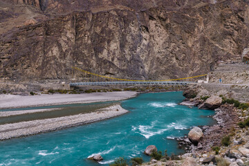 Autumn view Flowing blue water of Gilgit River with Hindu Kush mountain range in the background,Gahkuch, Pakistan.
