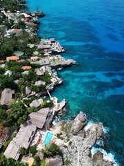 Aerial drone view of the dramatic cliffs of Negril, Jamaica, with turquoise Caribbean waters, lush...