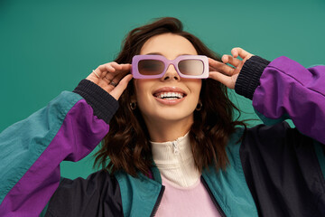 Stylish young woman showcasing sporty fashion on a vibrant turquoise backdrop