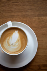 Cup of coffee with latte art on wooden table perfect for morning relaxation or cozy cafe atmosphere