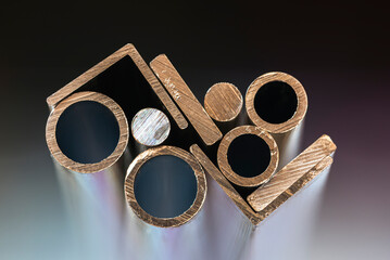 Set of aluminum profiles of various shapes, a close-up of a cross-section, with a blurred soft...
