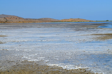 Salt Flat Landscape with Distant Hills under Clear Blue Sky
