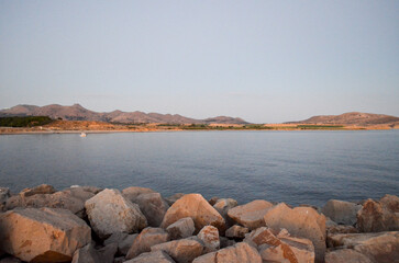 Tranquil Coastal Landscape with Rocky Shore and Distant Hills