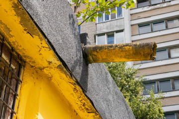 Unusual urban detail showcases weather-beaten pipe against modern city backdrop
