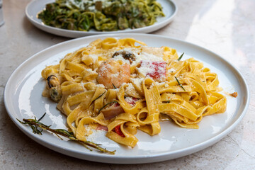 Delicious seafood fettuccine served on a white plate in a modern restaurant setting during lunchtime