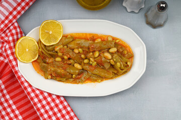 Homemade stewed green beans, tomatoes, garlic with olive oil. Zeytinyagli fasulye traditional food. Turkish cuisine.