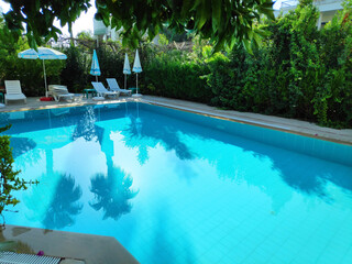 Pool with a blue tiled floor and a white umbrella