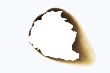A large, irregular burnt hole in white paper, with scorched edges creating an abstract frame. A powerful grunge texture and fire damage effect. Isolated on white background with clipping path.