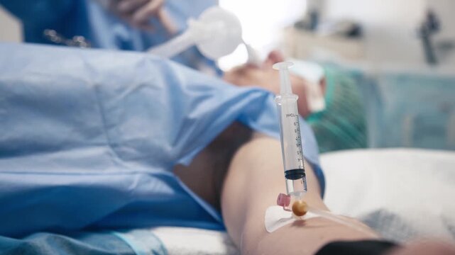 Close-up of a male patient's hand with an intravenous catheter and syringe under anesthesia. Concept medical intervention and patient care.