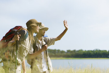 Man and woman are enjoy seeing a beautiful landscape and lake view.