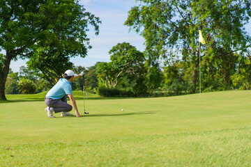 Fototapeta premium Asian man enjoying the morning round of golf in soft and warm sunlight.