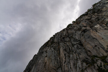 low angle view of the cliff against the cloudy sky