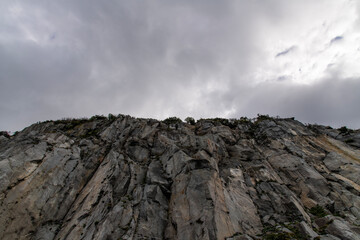 low angle view of the cliff against the cloudy sky