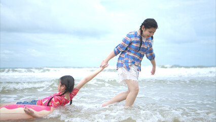 Obraz premium Happy children playing together in the sea, enjoying a fun summer day at the beach