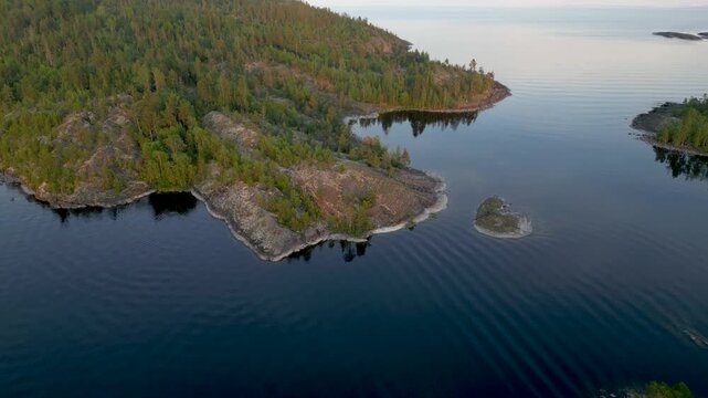 Aerial view of islands covered with green trees contrasting with the dark blue water creating a serene and scenic landscape, Sortavala, Russia.