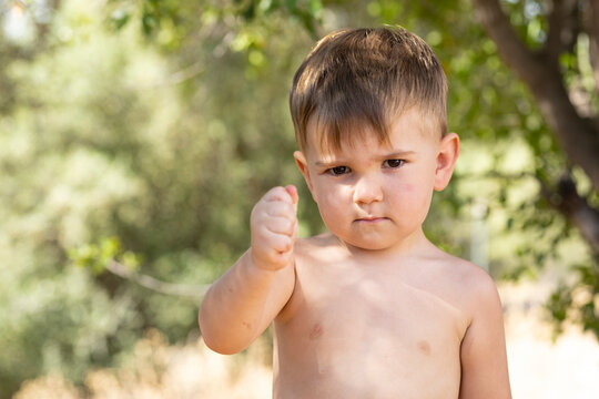 Ni&ntilde;o peque&ntilde;o mostrando sus m&uacute;sculos y haciendo un gesto de fuerza al aire libre, concepto de empoderamiento infantil.