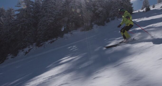Skiing through fresh winter powder on a sunny mountain slope in vibrant gear