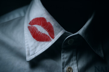 Lipstick kiss stain on crisp white shirt collar, close up evidence of secret affair, romantic betrayal concept, infidelity clue symbolizing cheating partner, unfaithful relationship suspicion, seducti