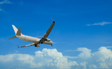 Airplane flying in beautiful blue sky with clouds