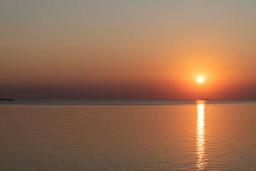 Sunset over calm waters with reflection creating a serene atmosphere in the evening sky