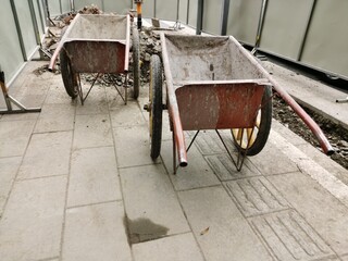 Metal wheelbarrows standing at construction site for Repairing the road surface
