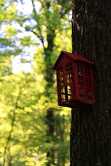 red bird house on a tree