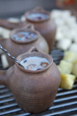 Traditional earthenware pots filled with a sweet, creamy herbal drink, photographed at a street food stall in Yunnan, China