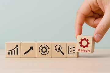 Hand Holding Wooden Block with "Kaizen" Text and Gear Icon, Business Improvement Concept, Sustainable Growth Strategy