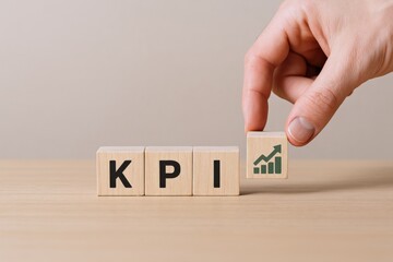 Hand placing a wooden block with a rising graph icon on top, representing KPI performance metrics and business growth analysis