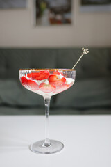 Tasty fruit dessert with sliced strawberries and whipped cream on white background, minimalist food concept.