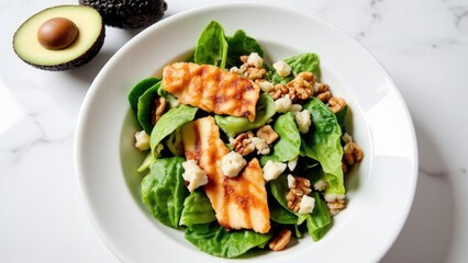 Healthy keto salad bowl on marble countertop: baby spinach, avocado, walnuts, grilled chicken slices, vibrant blue-cheese crumbles. Fresh, colorful, and perfect for low-carb meals.