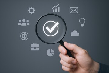 Hand holding magnifying glass focusing on checkmark icon with digital technology and internet symbols overlay for online success and verification