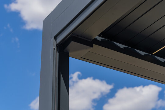 Fototapeta Zoom sur les finitions soignées d’une pergola gris anthracite installée par une entreprise spécialisée, mettant en valeur la qualité de la structure et des matériaux.