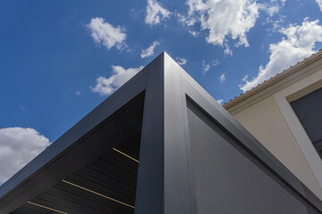 Zoom sur les finitions soignées d’une pergola gris anthracite installée par une entreprise spécialisée, mettant en valeur la qualité de la structure et des matériaux.