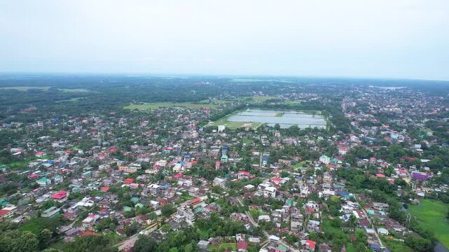 4K Aerial Drone View of Colorful Town with Lush Greenery and Water Reservoir

