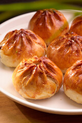 Famous Malaysia local fresh-baked crispy BBQ pau on a white plate and black background